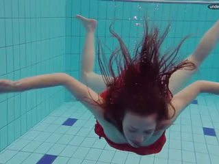 Vermelho vestido jovem grávida a nadar com dela olhos aberto